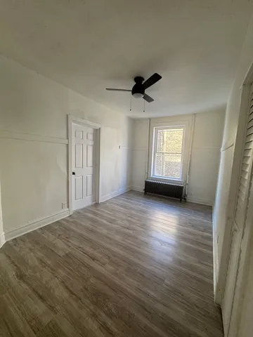 a view of a livingroom with wooden floor and a ceiling fan