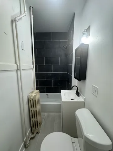 a bathroom with a toilet a sink and mirror