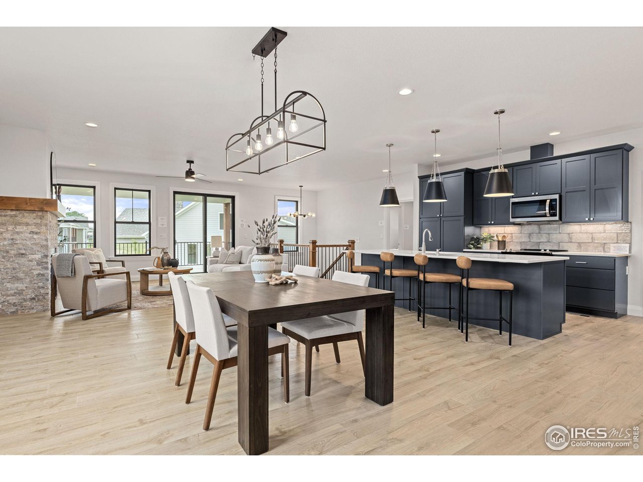 217 57th Avenue Greeley, CO 80634 - Photo 7 of 35 a dining room with wooden floor a chandelier a wooden table and chairs