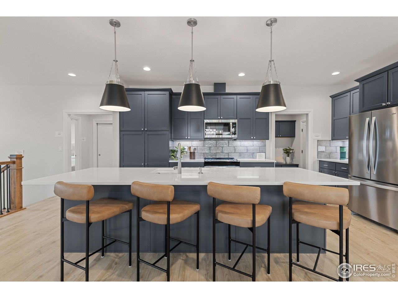 217 57th Avenue Greeley, CO 80634 - Photo 10 of 35 a kitchen with stainless steel appliances kitchen island a table chairs sink and cabinets
