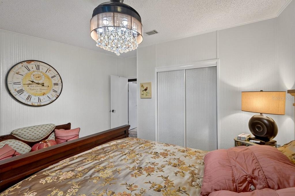 747 Navigators Way Edgewater, FL 32141 - Photo 48 of 73 a bedroom with a bed and a chandelier