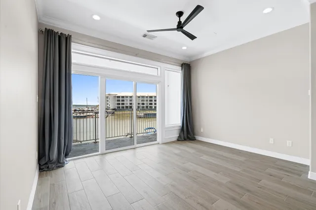 a view of a livingroom with wooden floor and a ceiling fan