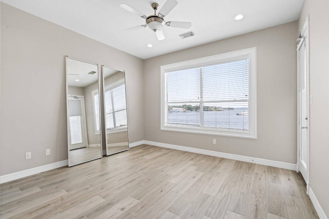 168 Lake Point Boulevard, Unit C202 Conroe, TX 77356 - Photo 5 of 14 an empty room with wooden floor and windows