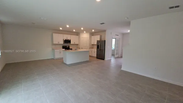 a view of a kitchen with a sink and a refrigerator