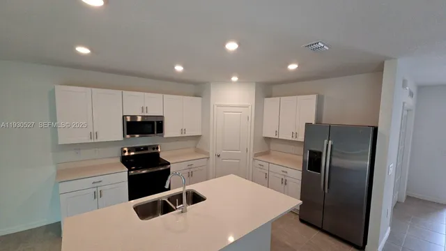 a kitchen with stainless steel appliances a refrigerator stove microwave and sink