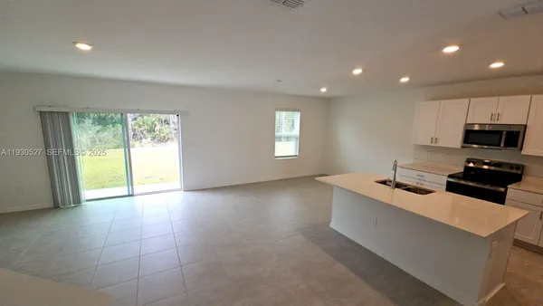 a kitchen with a sink a microwave and cabinets