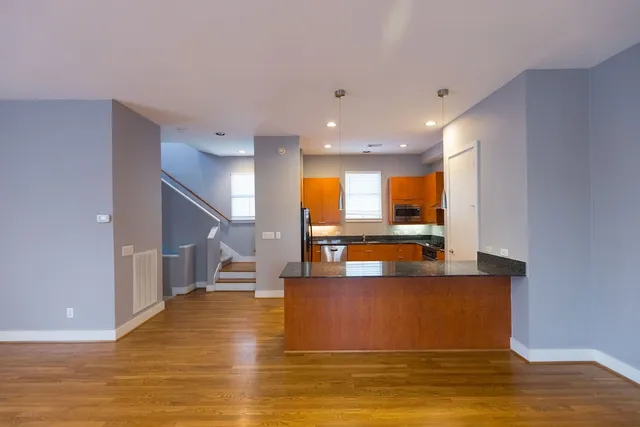 a kitchen with stainless steel appliances granite countertop a sink a stove and a wooden floors