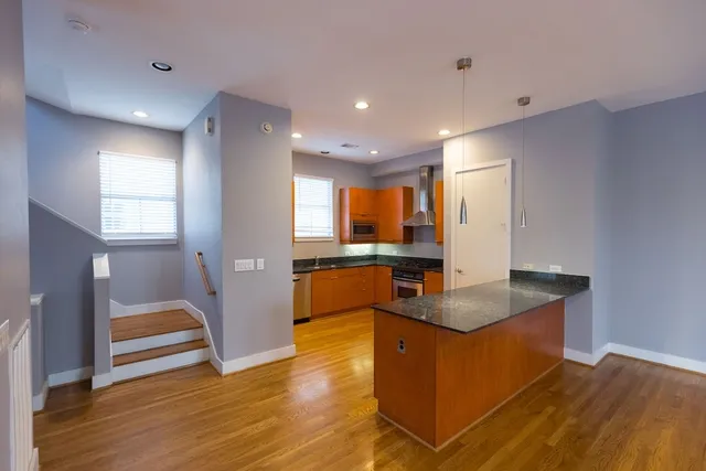 a view of a living room with kitchen countertops and wooden floor