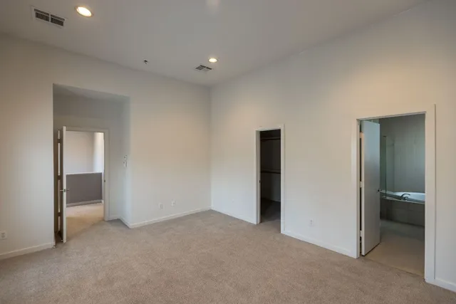 an empty room with closet and a bathroom
