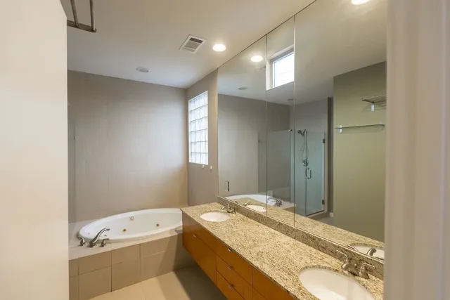 a bathroom with a granite countertop sink a large mirror a toilet and a bathtub
