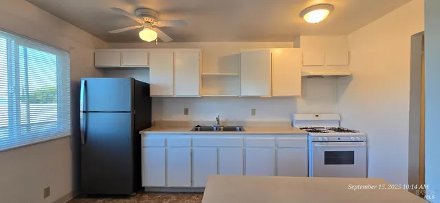 a kitchen with stainless steel appliances a refrigerator sink and cabinets