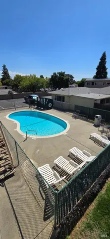 a view of a swimming pool with an outdoor seating and a yard