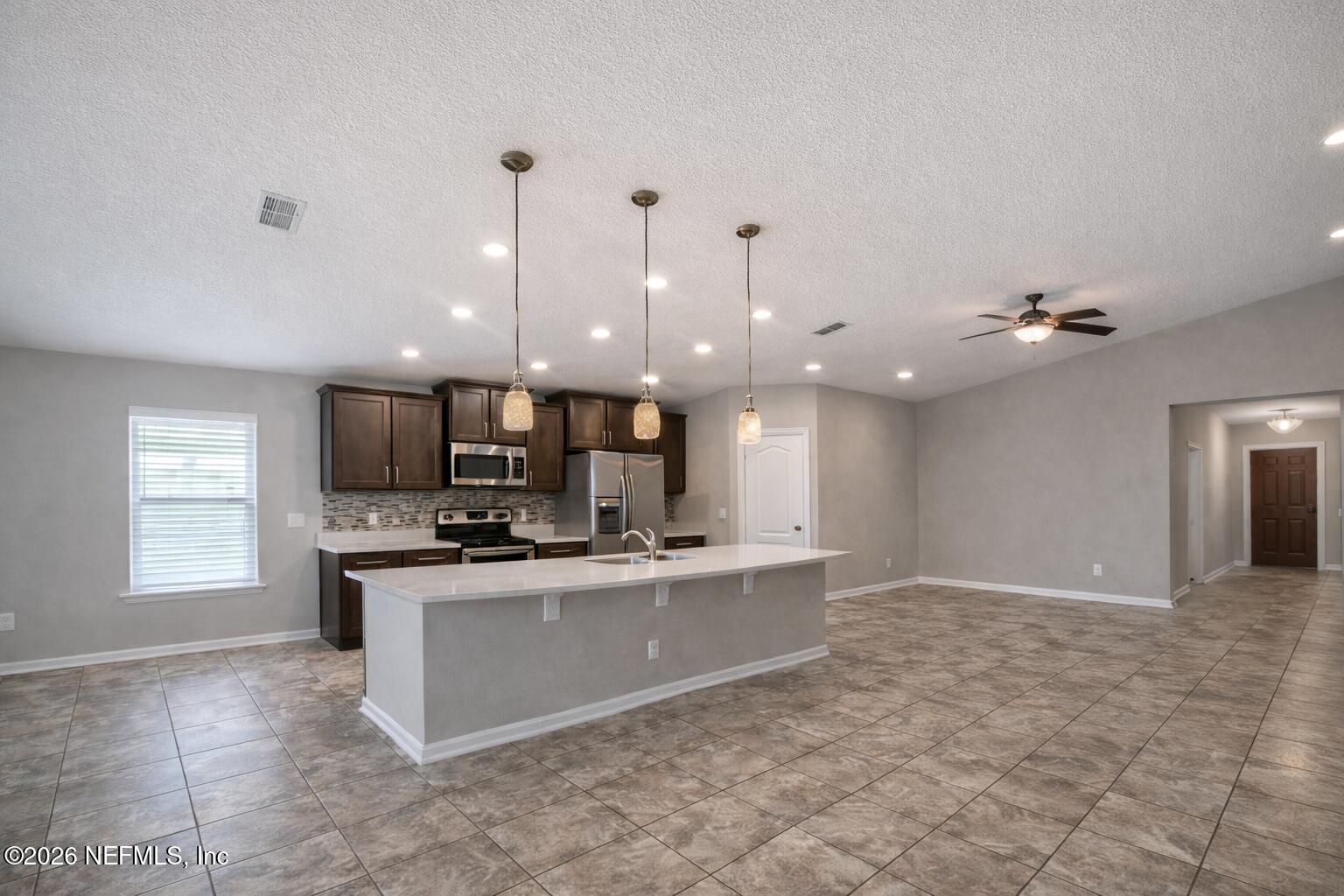 5937 Round Table Road Jacksonville, FL 32254 - Photo 3 of 10 a kitchen with kitchen island a sink stainless steel appliances and cabinets