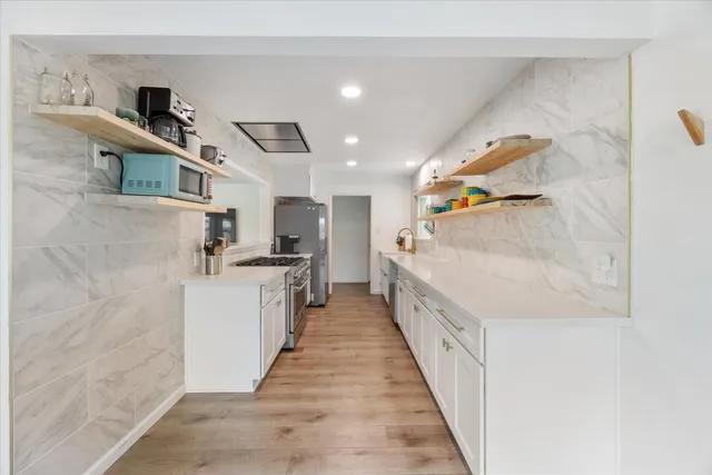 a kitchen with white cabinets and sink