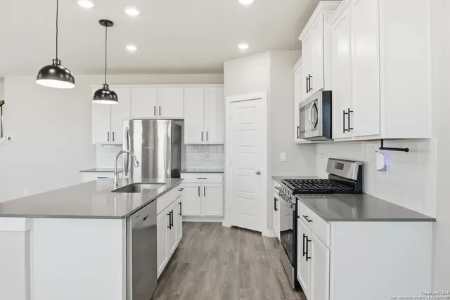 a kitchen with stainless steel appliances granite countertop a sink stove and refrigerator