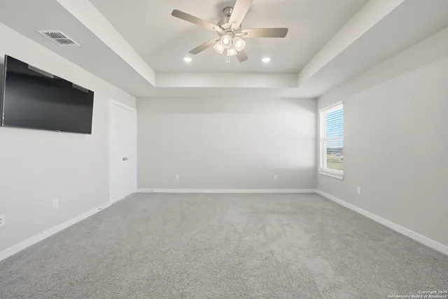 an empty room with windows and fan