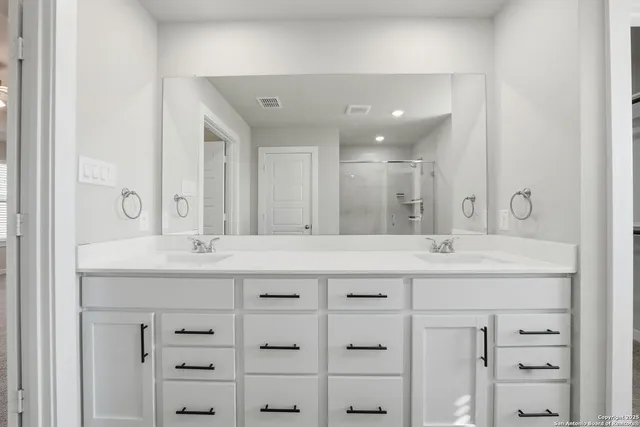 a bathroom with a granite countertop sink mirror and cabinets