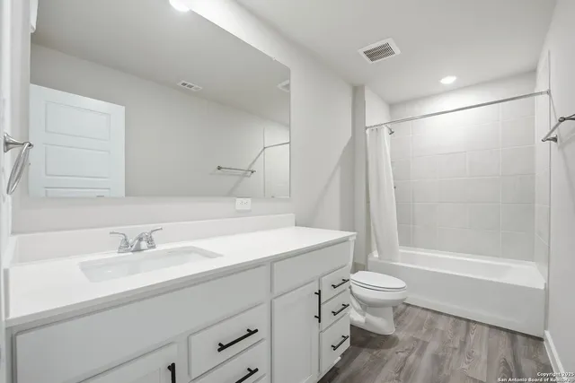 a bathroom with a sink a toilet and a large mirror