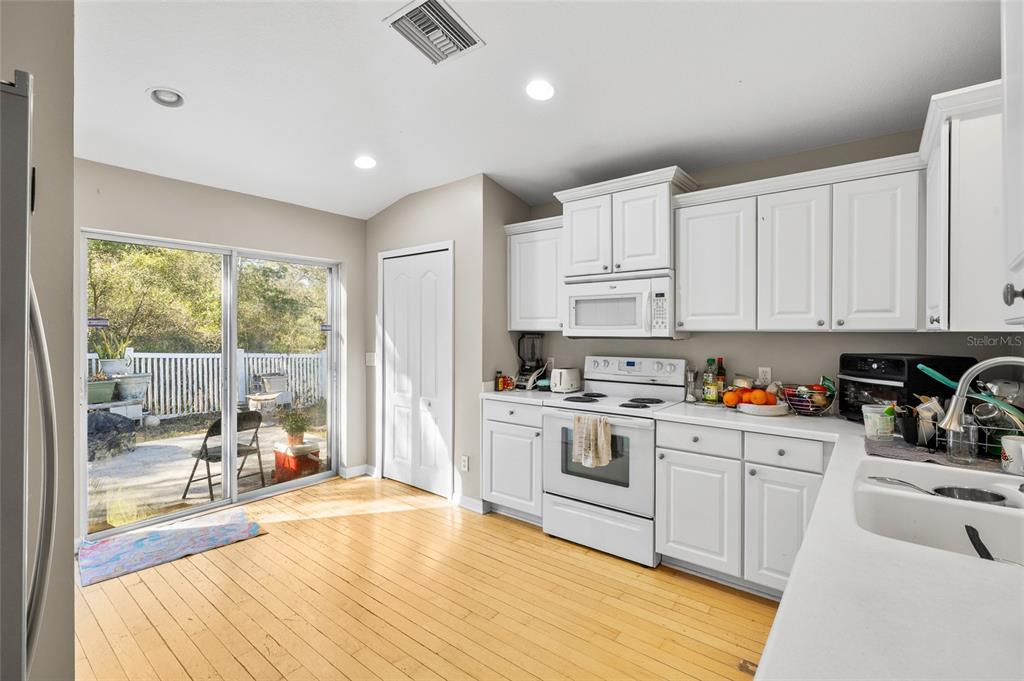 12113 Deertrack Loop Spring Hill, FL 34610 - Photo 12 of 31 a kitchen with white cabinets and white appliances