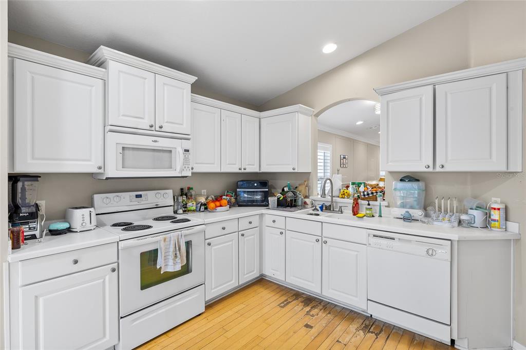 12113 Deertrack Loop Spring Hill, FL 34610 - Photo 14 of 31 a kitchen with white cabinets stainless steel appliances and sink