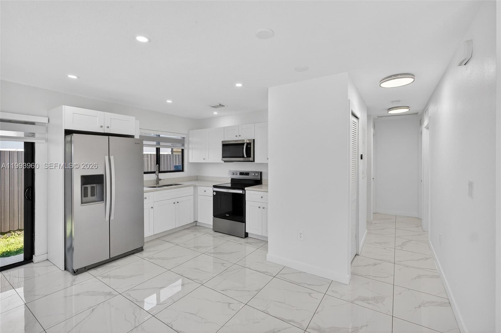 2492 Southwest 44th Street, Unit 2492 Miami, FL 33185 - Photo 12 of 34 a kitchen with stainless steel appliances a refrigerator sink and cabinets