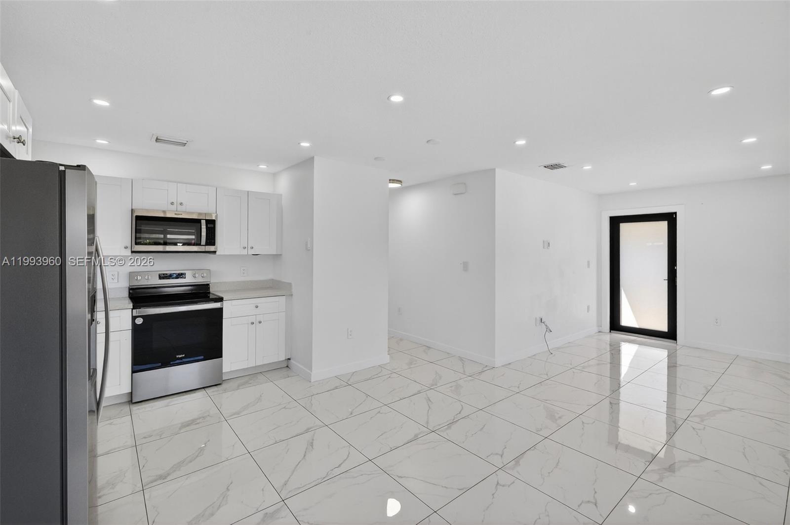 2492 Southwest 44th Street, Unit 2492 Miami, FL 33185 - Photo 9 of 34 a kitchen with granite countertop a refrigerator and a stove top oven