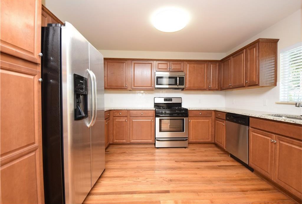 2817 East 22nd Street Austin, TX 78722 - Photo 14 of 18 a kitchen with stainless steel appliances wooden cabinets and a refrigerator