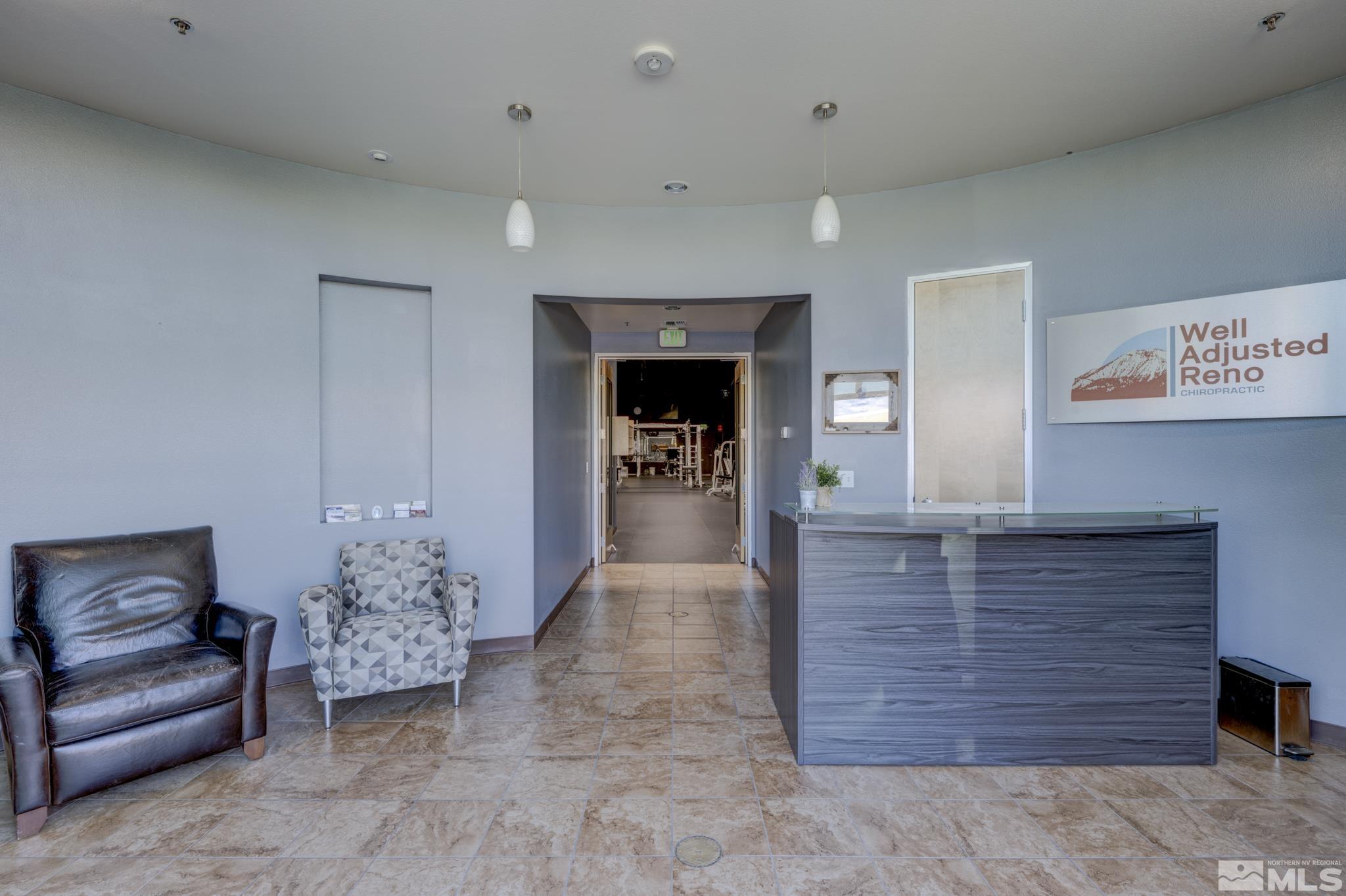 8975 Double Diamond Parkway, Unit 12A Reno, NV 89521 - Photo 5 of 8 a hallway with a couches and a fireplace