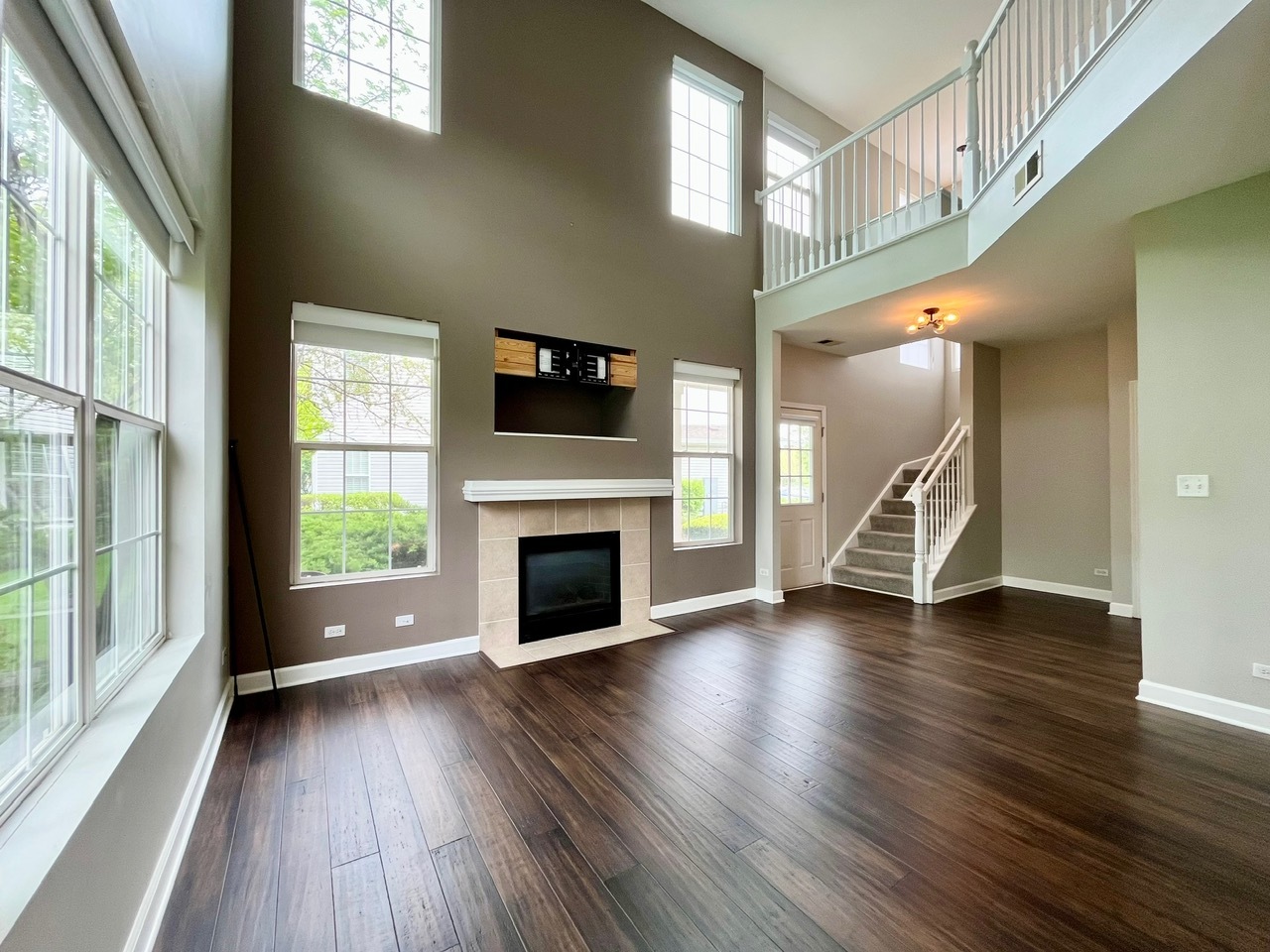 1919 Golden Gate Lane Naperville, IL 60563 - Photo 2 of 18 a view of an empty room with wooden floor fireplace and a window