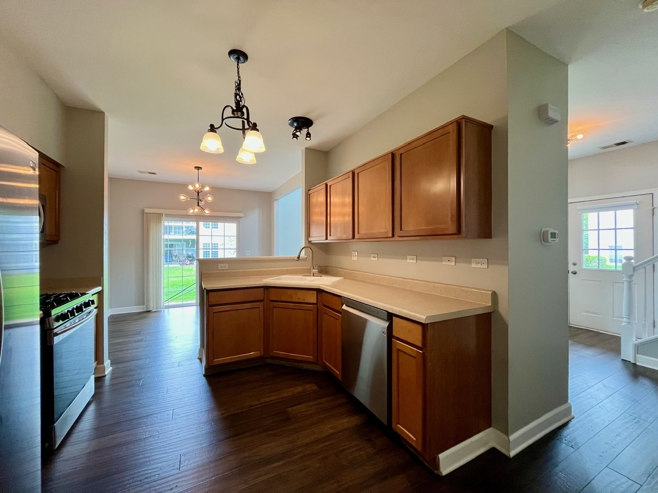 1919 Golden Gate Lane Naperville, IL 60563 - Photo 6 of 18 a kitchen with stainless steel appliances granite countertop a stove and a wooden floors