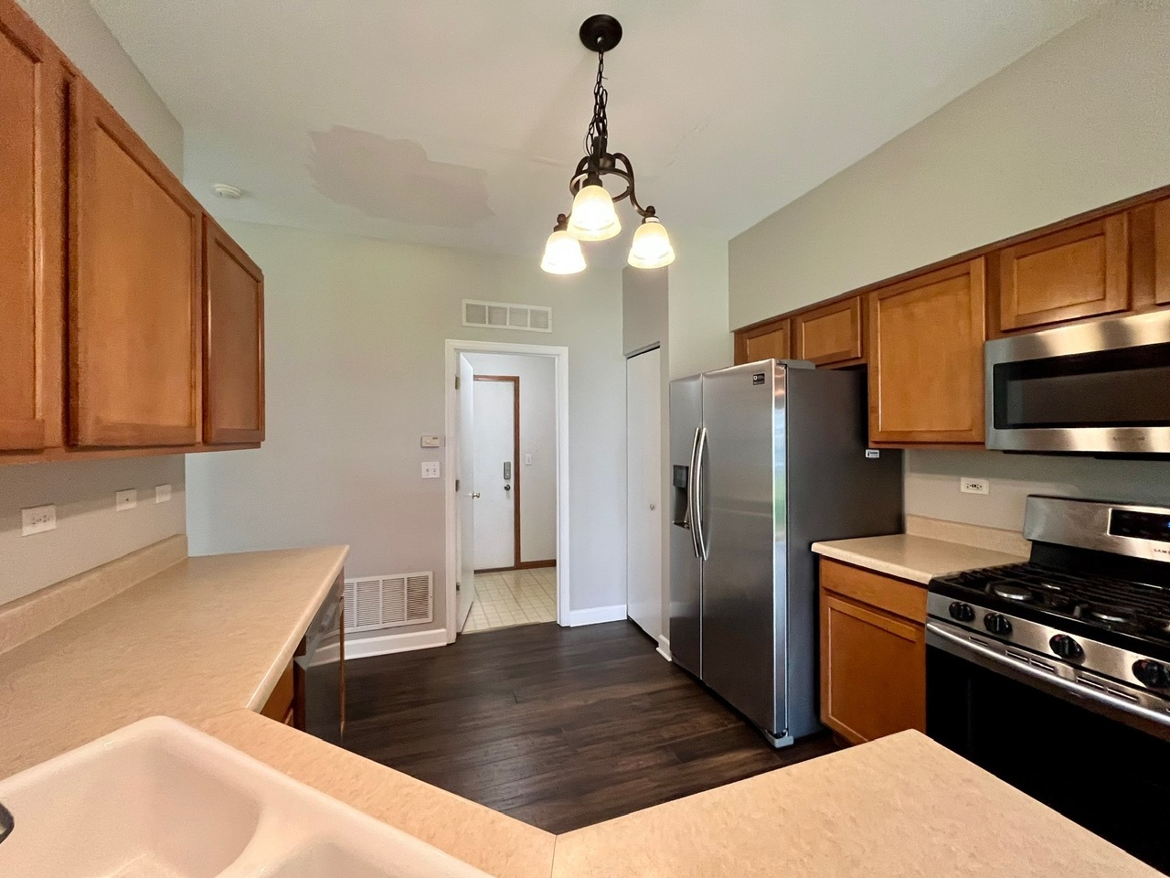 1919 Golden Gate Lane Naperville, IL 60563 - Photo 7 of 18 a kitchen with stainless steel appliances granite countertop a refrigerator a stove and a sink with wooden floor