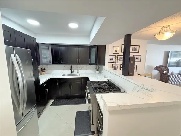 a kitchen with stainless steel appliances a refrigerator sink and microwave