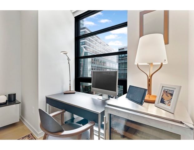 a view of a workspace room with furniture and wooden floor