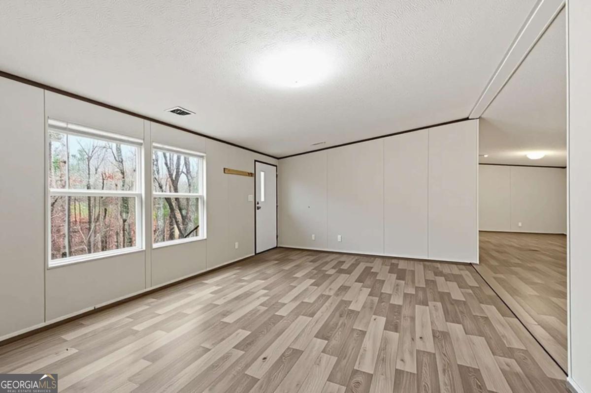 2232 Grandview Road Jasper, GA 30143 - Photo 2 of 29 a view of an empty room with a window and hardwood floor
