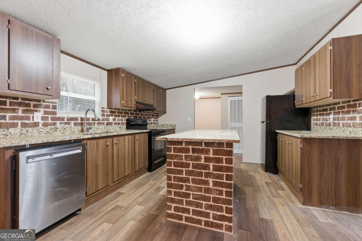 2232 Grandview Road Jasper, GA 30143 - Photo 8 of 29 a kitchen with kitchen island wooden cabinets stainless steel appliances a sink and a counter space