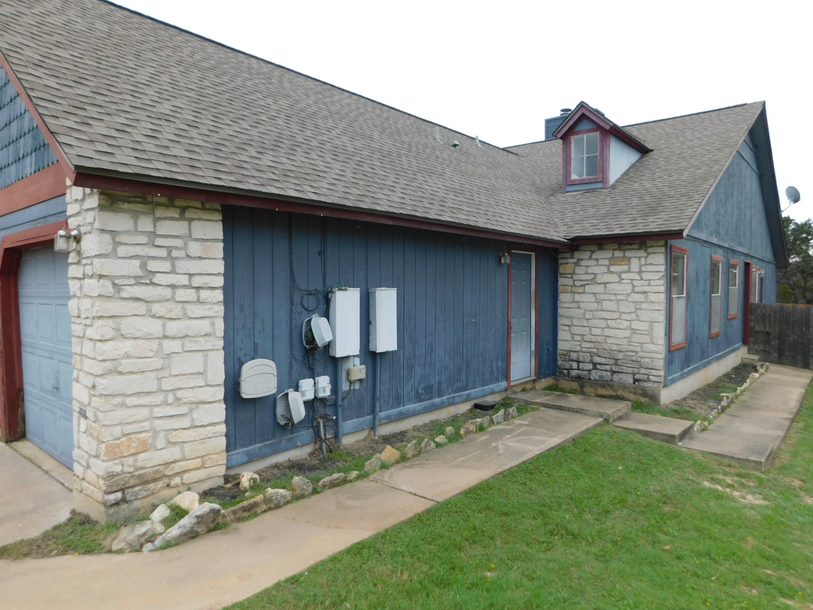 522 Cutty Trail, Unit B Lakeway, TX 78734 - Photo 17 of 20 A quaint residence featuring mixed stone and siding construction, complete with a practical attached garage and dormer window.