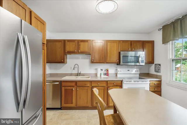 a kitchen with stainless steel appliances a stove refrigerator sink and microwave