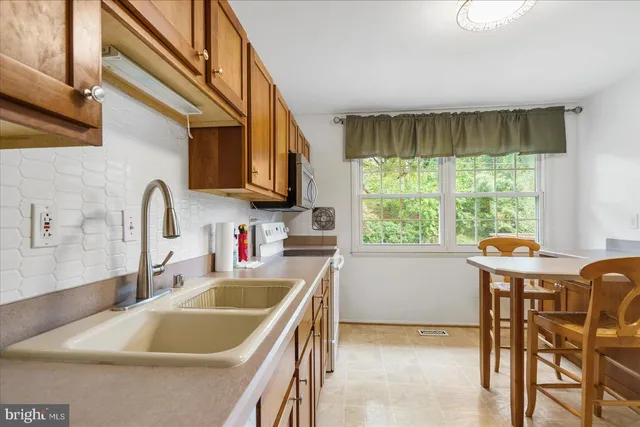 a kitchen with a table chairs a sink and a stove