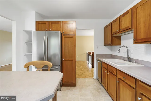 a kitchen with stainless steel appliances granite countertop a refrigerator a sink and a stove