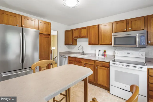 a kitchen with stainless steel appliances granite countertop a refrigerator stove microwave and sink