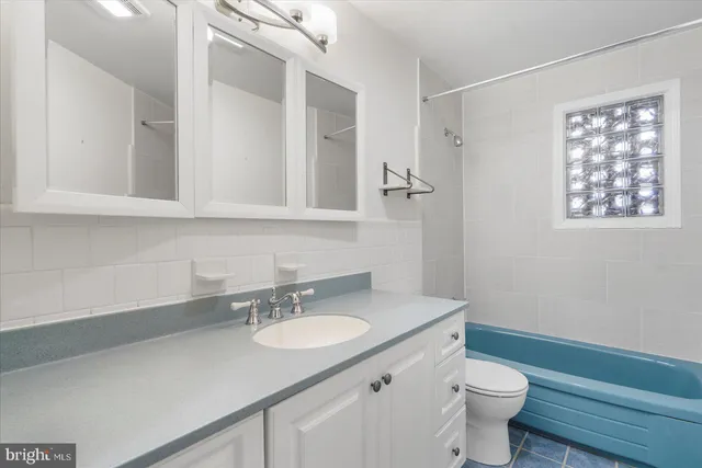 a bathroom with a granite countertop sink toilet and a mirror