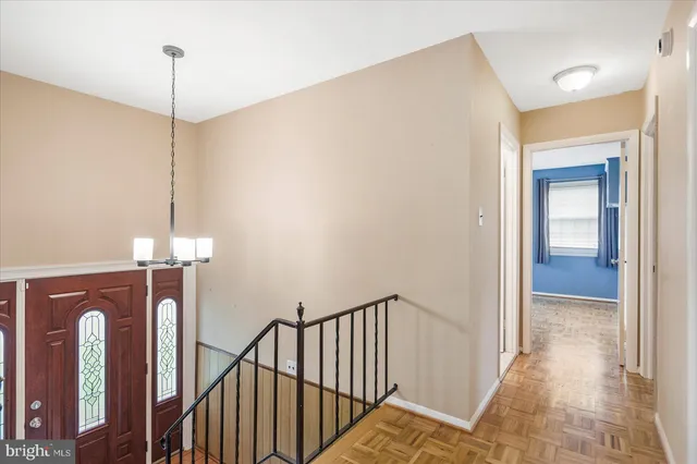 a view of a hallway with chandelier and entryway