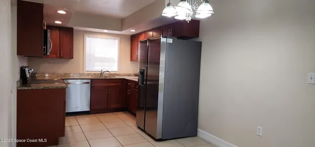 a kitchen with stainless steel appliances granite countertop a refrigerator and a sink