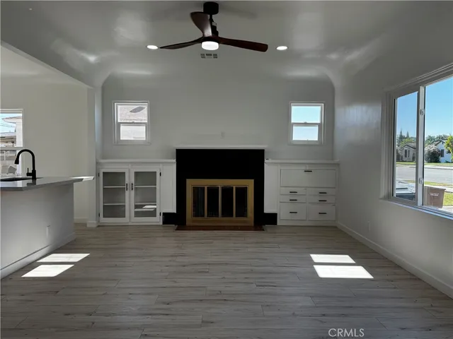a view of an empty room with a fireplace and window