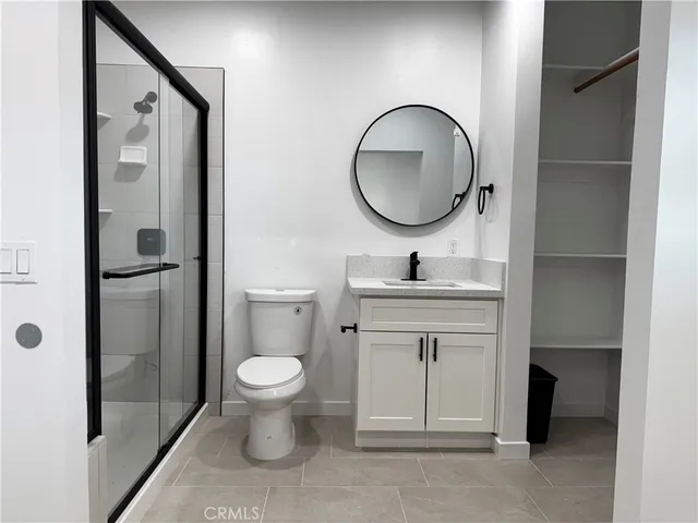 a bathroom with a toilet sink vanity and mirror