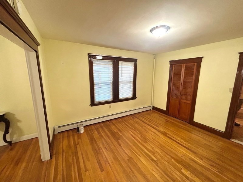 119 Bailey Road, Unit 1 Somerville, MA 02145 - Photo 14 of 25 an empty room with wooden floor and windows