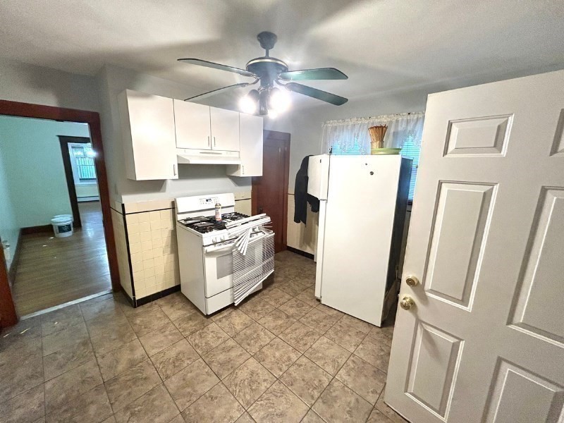 119 Bailey Road, Unit 1 Somerville, MA 02145 - Photo 17 of 25 a kitchen with a refrigerator a stove a microwave and cabinets