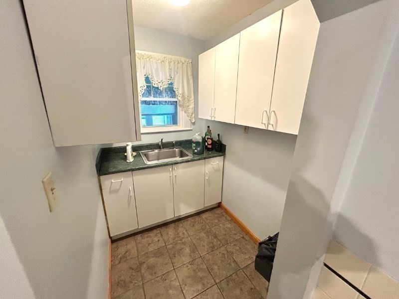 119 Bailey Road, Unit 1 Somerville, MA 02145 - Photo 18 of 25 a kitchen with a sink a window and cabinets