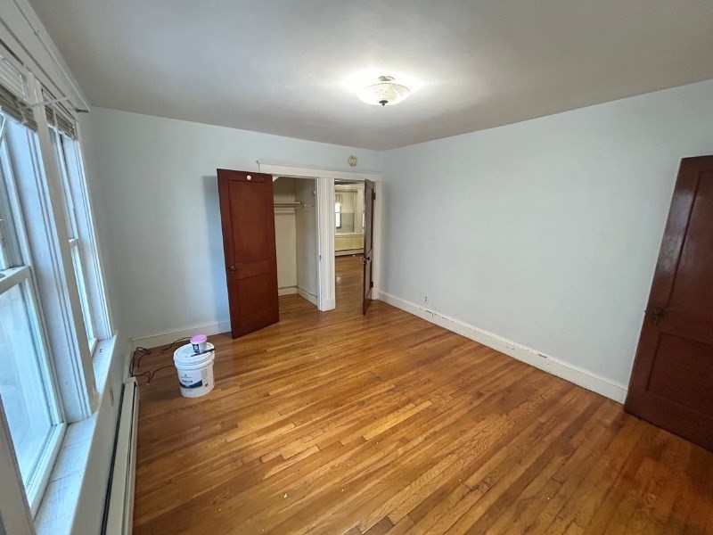 119 Bailey Road, Unit 1 Somerville, MA 02145 - Photo 6 of 25 an empty room with wooden floor and entrance