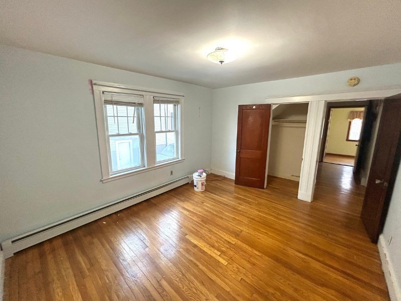 119 Bailey Road, Unit 1 Somerville, MA 02145 - Photo 7 of 25 an empty room with wooden floor and windows